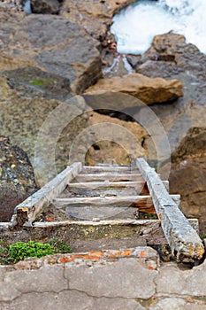 Old wooden ladder on rock cliff on ocean coast
