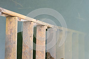 Old wooden ladder in the water close up