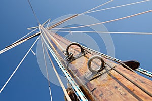 Old wooden mast with crosspieces and backstays, view from deck
