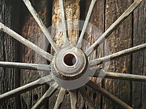 Old wooden metal wheel on the old wooden wall background photo