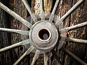 Old wooden metal wheel on the old wooden wall background photo