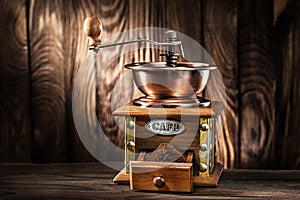 Old wooden mill with coffee sand on vintage wooden background