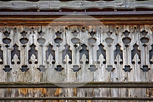 Old wooden ornamented design of balcony in small village in Swiss Alps
