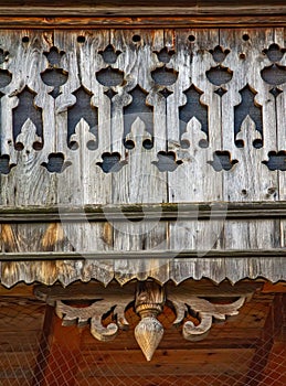 Old wooden ornamented design of balcony in small village in Swiss Alps