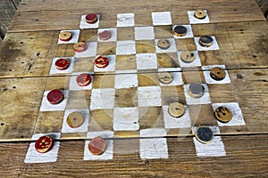Old Wooden Painted Checkers Board with Red and Black Pieces