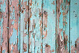 Old wooden painted light blue rustic fence, paint peeling background.