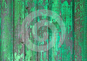 Old wooden painted light green rustic fence, paint peeling background.