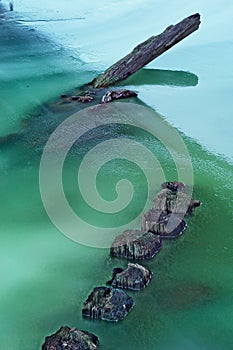 Old wooden pales in frozen river