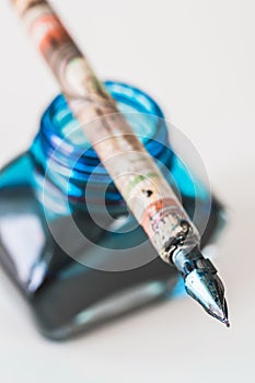 Old wooden penholder with steel nib on an inkwell