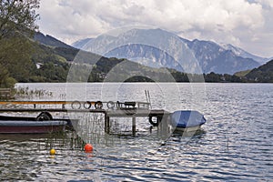 Old wooden pier with boats on Alpine lake Mondsee