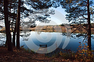 Old wooden pier for fishing in autumn forest lake