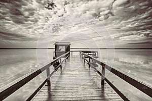 Old wooden pier for fishing, small house shed and beautiful lake