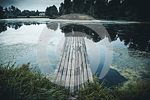 Old wooden pier in lake, Idyllic tranquil view nature background with reflection in water