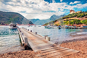 Old wooden pier in Port de Girolata - place, where you can`t get by car. Sunny summer scene of Corsica island, France, Europe. Be