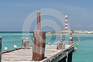 Old wooden pier and red and white lighthouse