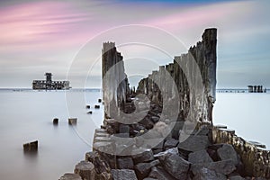 Old wooden pier and ruins of torpedo factory