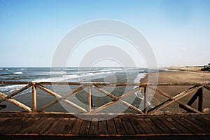 old wooden pier from the year 1916 with railing in the pacific ocean and blue sky pimentel chiclayo peru -june 2018 photo