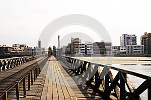 old wooden pier from railing in the pacific ocean and blue sky pimentel chiclayo peru photo