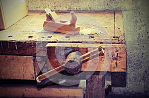 old wooden plane on the table of the workshop of carpenter with photo