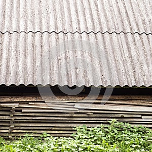 Old wooden planks stacked under the roof of old shed.