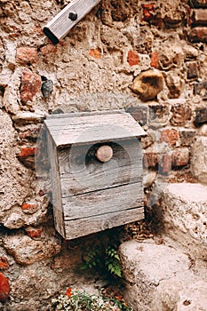 Old wooden post box on stone wall in Perouges, France