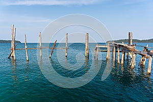 Old wooden post of a collapsed jetty photo