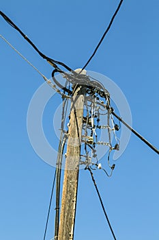 Old wooden powerline, isolated on blue sky