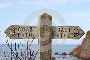 Old wooden public footpath sign overlooking Hope Cove in Devon, United Kingdom
