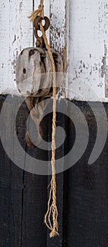 old wooden pulley attached to a rope on