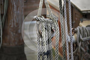 Old wooden pulley block with weathered ropes on an historic sailing boat