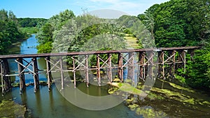 Old wooden railroad aerial over split river in forest