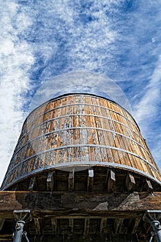 An old wooden railroad water tank raised on scaffolding