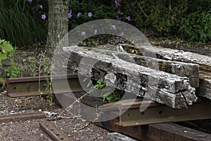 Old wooden railway sleepers rails and sleepers on the background of green grass