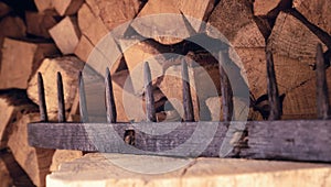 Old wooden rake on a background of wood stack