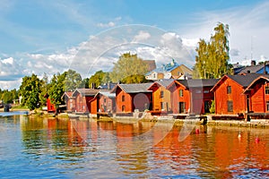 Old wooden red houses on the river coast in Porvoo, Finland.