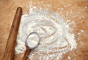 Old wooden rolling pin on a brown background, top view