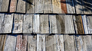Old wooden roof tiles background. Wood background. Vintage. Wood roofing pattern detail. Old brown wooden shingle roof.View of