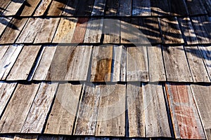Old wooden roof tiles background. Wood background. Vintage. Wood roofing pattern detail. Old brown wooden shingle roof.View of