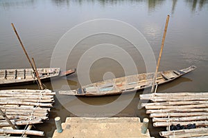 Old wooden row boat and raft on water