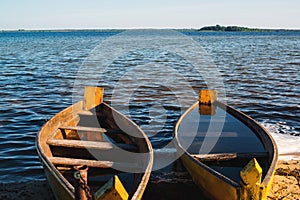 Old wooden rowing boats on a lake. Two fishing boats at beautiful sunset in summer morning. Summer vacation. Beautiful lake with