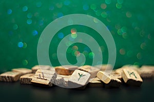 Old wooden runes on a green bokeh background