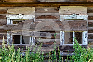 Old wooden rustic ruined abandoned house with boarded up windows on a bright summer sunny day