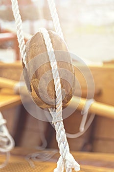 Old wooden sailboat pulleys and ropes detail.