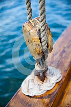 Old wooden sailboat rope attached to pulley