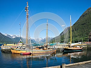 Old wooden sailboats are in the marina in Andalsnes, Norway