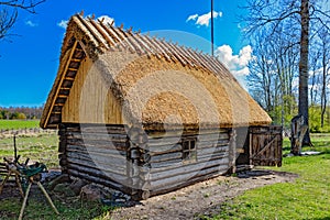 Old wooden sauna log cabin with thatched roof. Hiiumaa island, E