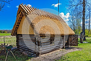 Old wooden sauna log cabin with thatched roof. Hiiumaa island, E photo