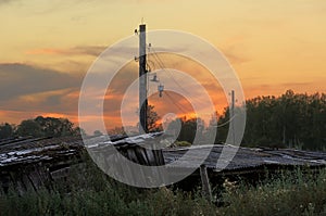 Old wooden shed and pole in the country in sunset