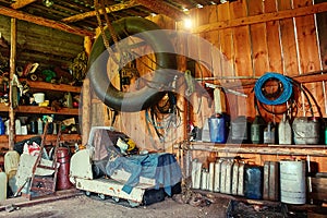 An old wooden shed on a remote cordon, with a tool for repairing equipment, with a group of old canisters and cylinders for