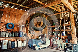 An old wooden shed on a remote cordon, with a tool for repairing equipment, with a group of old canisters and cylinders for